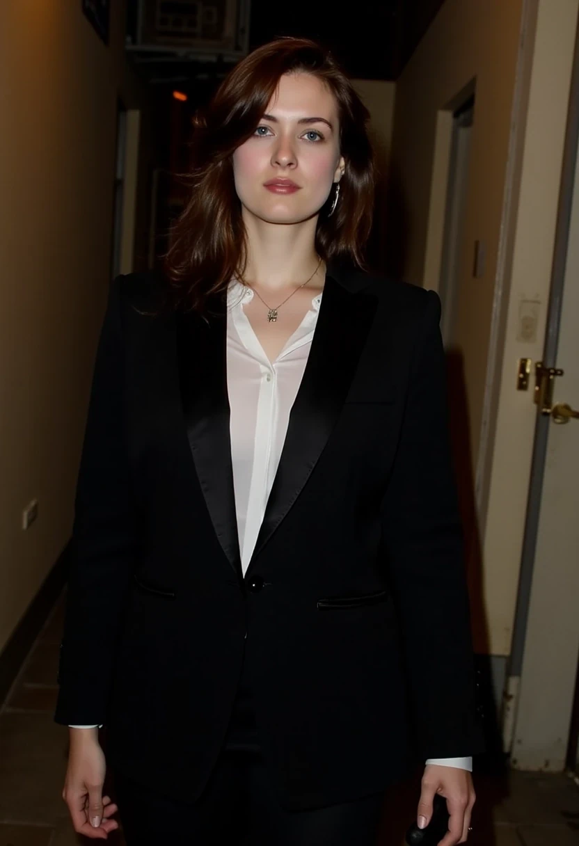 Woman CSTMDL, brunette, blue eyes, her hair are loose, she’s beautiful with a cold smile, wearing a tailored haute couture set, black blazer and skirt, elegant and modern, but very (sexy). She also wears a white shirt under the blazer. Her clothes molds her sculptural body. Her expression is haughty and contemptuous. She looks like someone cold and unfriendly. Her skin tone is very white, (pallid), almost cadaveric. She’s wearing a small pendant. She walks with grace, like a fashion model. The background is a small deserted Parisian alley by (night). The light is very low, making the scene a bit worrying and frightening.