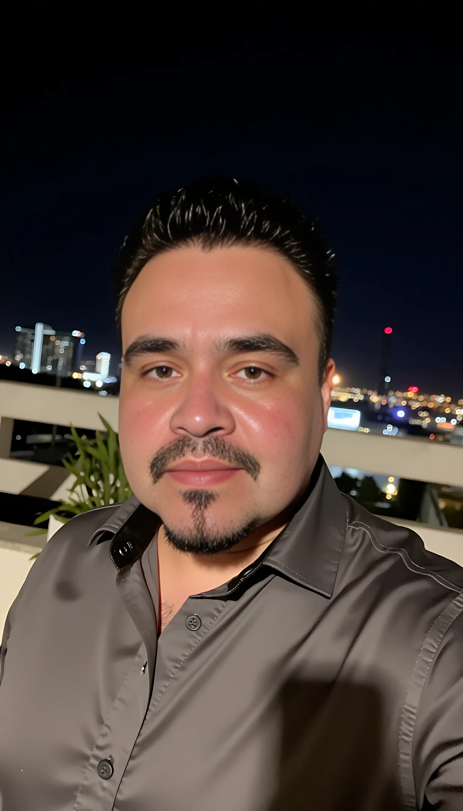 CSTMDL  selfie man average body wearing a Burberry shirt standing 
With city night lights on background 