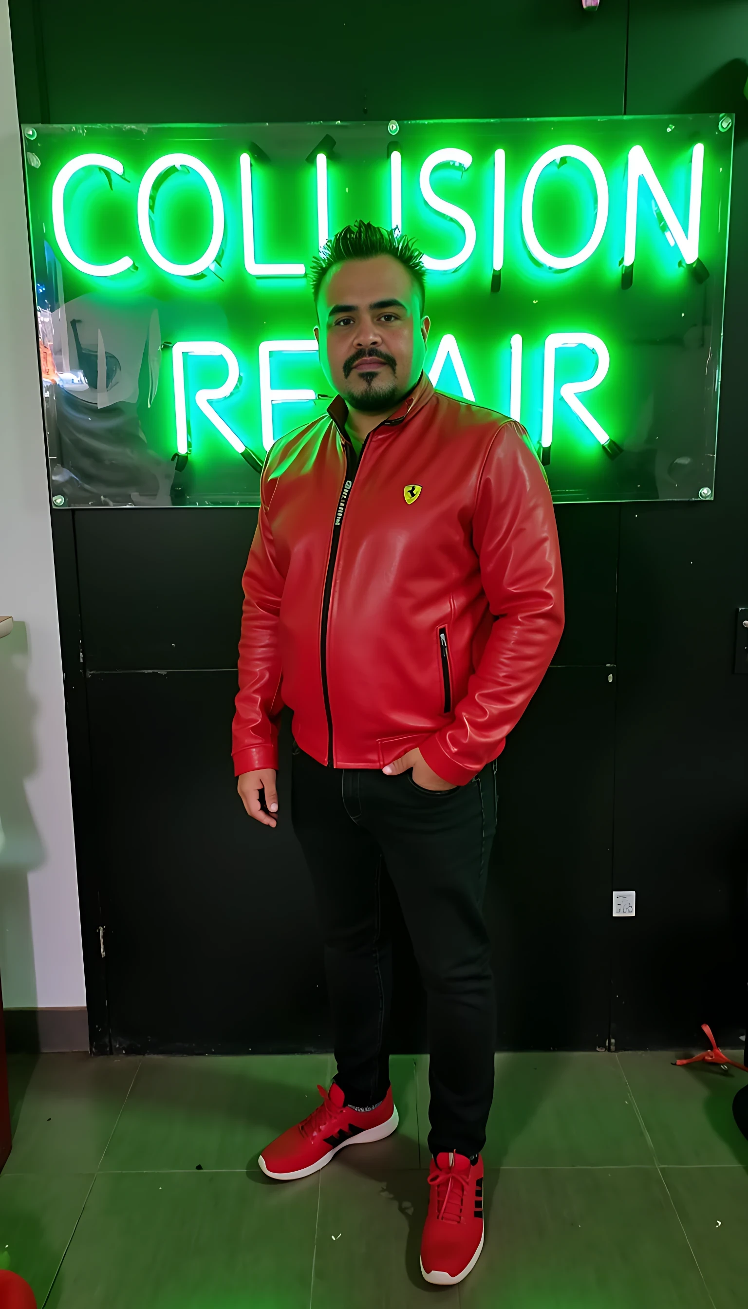 CSTMDL average man body  standing wearing a red leather jacket with a Ferrari logo and black jeans red tenis shoes with a green neon light sign that’s says  A4 COLLISION REPAIR.