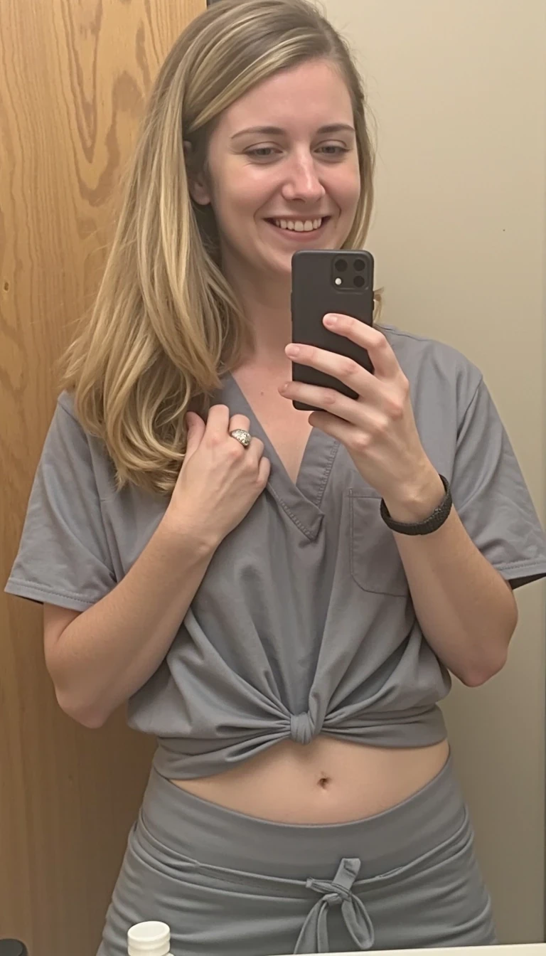 iphone 15 mirror selfie of 30s woman CSTMDL with long sandy blonde hair in single person public bathroom. She is wearing scrubs. She is pulling her shirt up to reveal her breasts. The iPhone is black