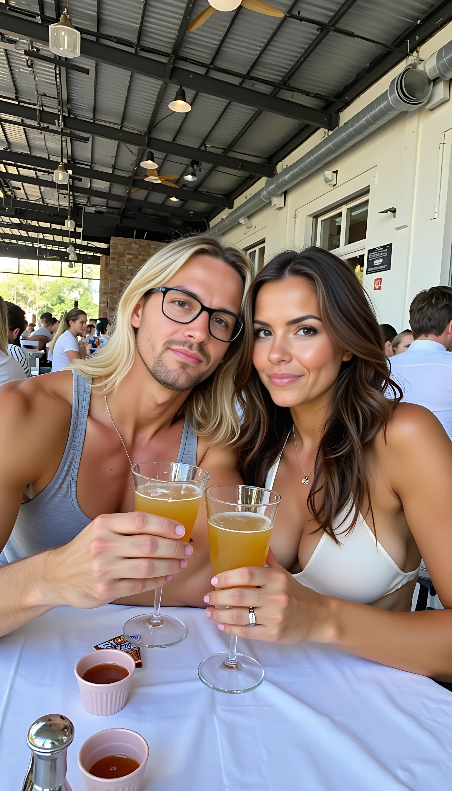 Medium shot photo of CSTMDL and a a beautiful women sitting closely together at a restaurant table, both holding drinks in a casual, friendly pose. The CSTMDL on the left has tan skin, long blonde hair, and wears glasses with a warm smile, dressed. The women on the right has a medium tan skin tone, dark wavy hair, and a relaxed expression, wearing a dress. They sit side by side, leaning slightly towards each other, suggesting camaraderie, with their arms resting on the white-clothed table, which has drinks, a menu, and utensils scattered across it. The background features an expansive indoor space with high ceilings, exposed metal beams, and large windows allowing bright natural light to fill the area. The restaurant ambiance is lively, with other patrons visible in the background, creating a bustling yet comfortable atmosphere. The overall lighting is bright, diffused through the windows, giving a soft glow to the scene, emphasizing the warm, friendly interaction between the two men.
