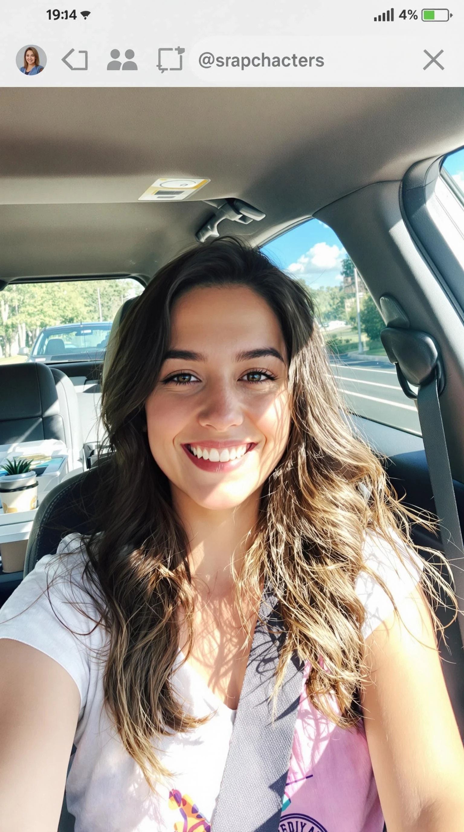 boring low quality snapchat photo circa 2015, A young woman with a warm smile, sitting in the driver's seat of a cozy car. She has soft, wavy brown hair cascading past her shoulders. The sunlight streams through the window, casting a gentle glow on her face. The interior of the car is neat and comfortable, with a coffee cup in the cup holder and a small plant on the dashboard. The background outside the window shows a scenic road lined with trees and blue skies