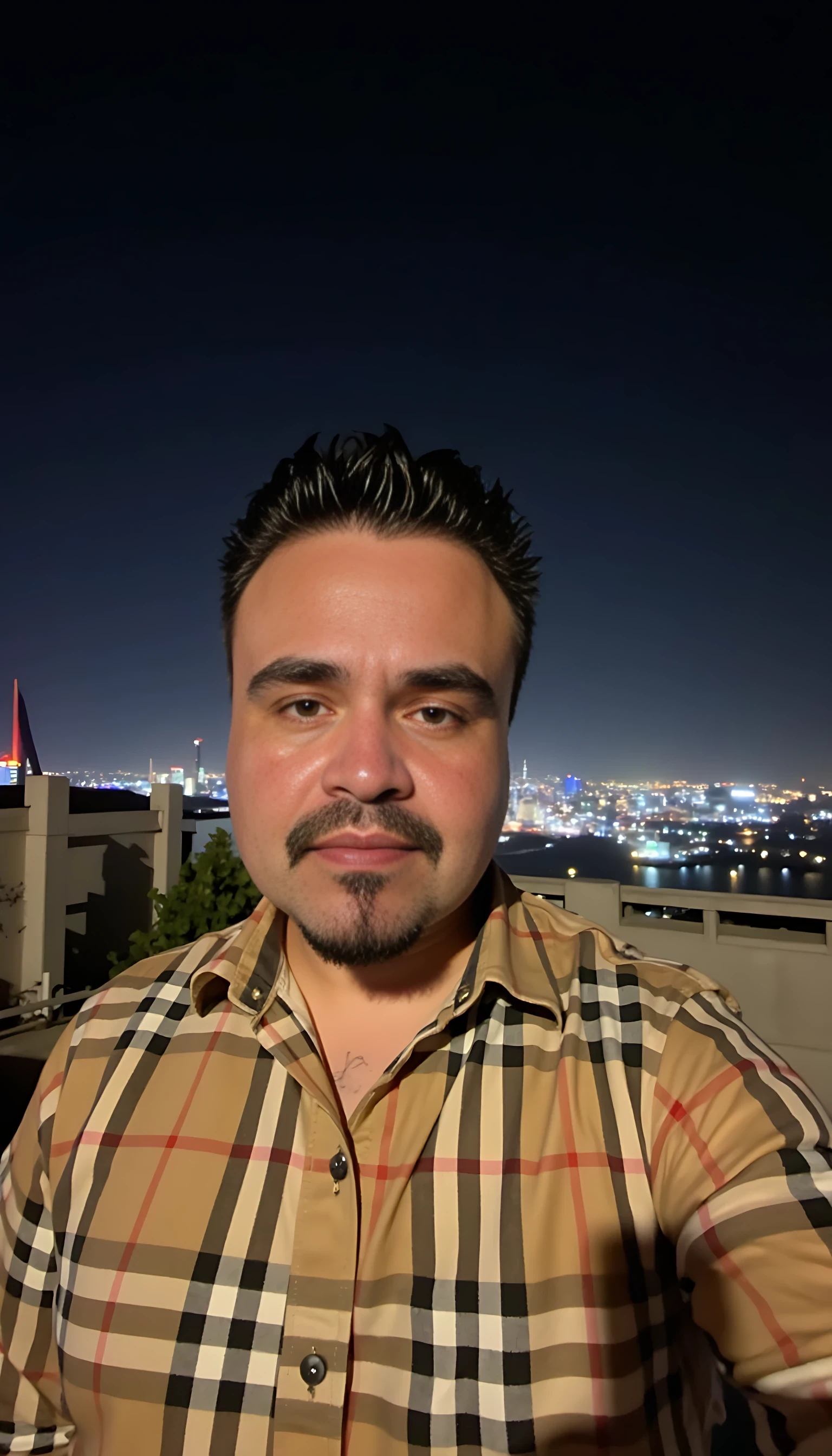 CSTMDL  selfie man average body wearing a Burberry shirt standing 
With city night lights on background 