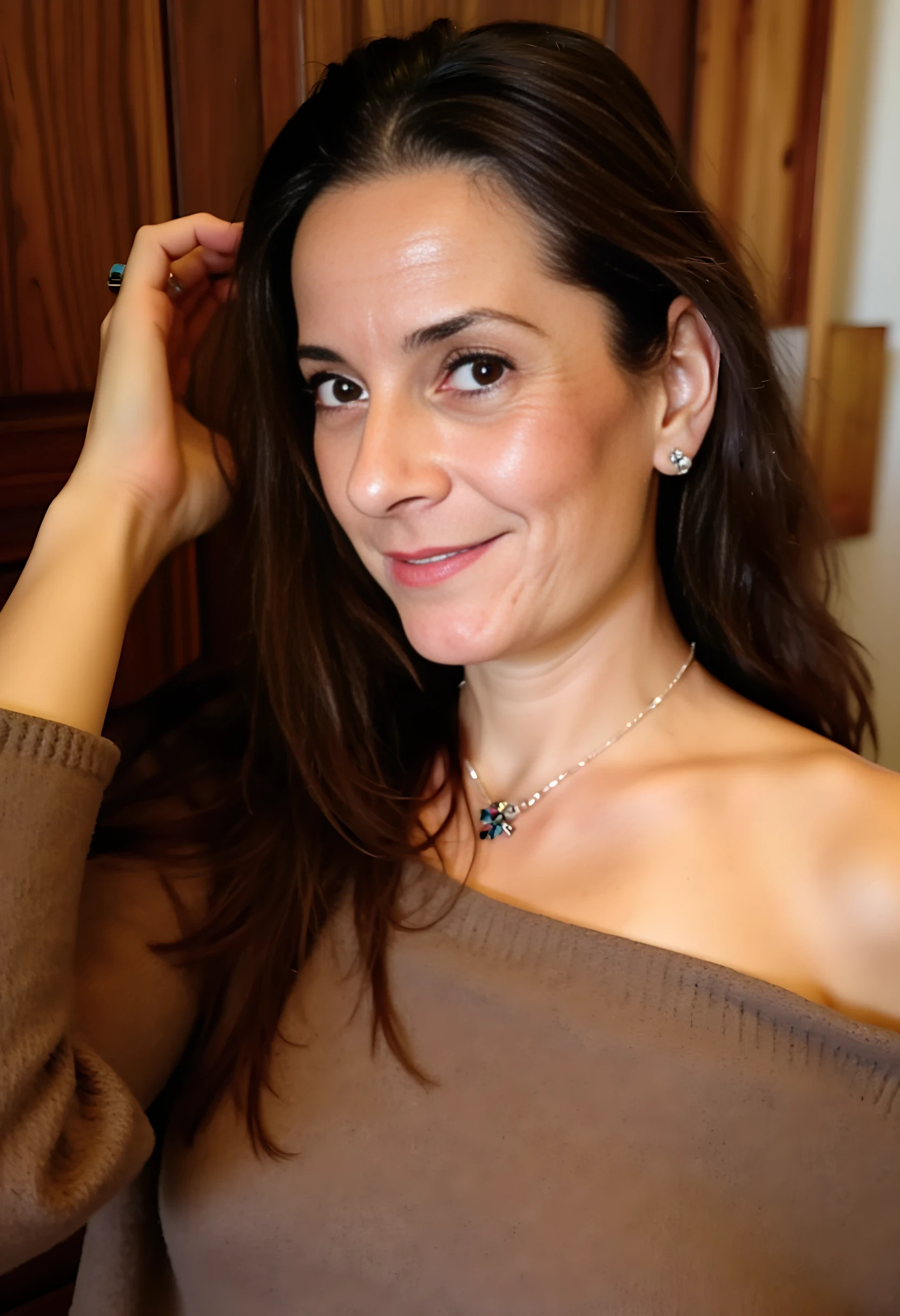 photo of woman CSTMDL, A woman with wavy dark brown hair, wearing an off-shoulder oversized brown knit sweater. She gazes softly toward the camera, slightly tilting her head, with her right hand gently brushing her hair. The lighting is warm, creating a cozy atmosphere.