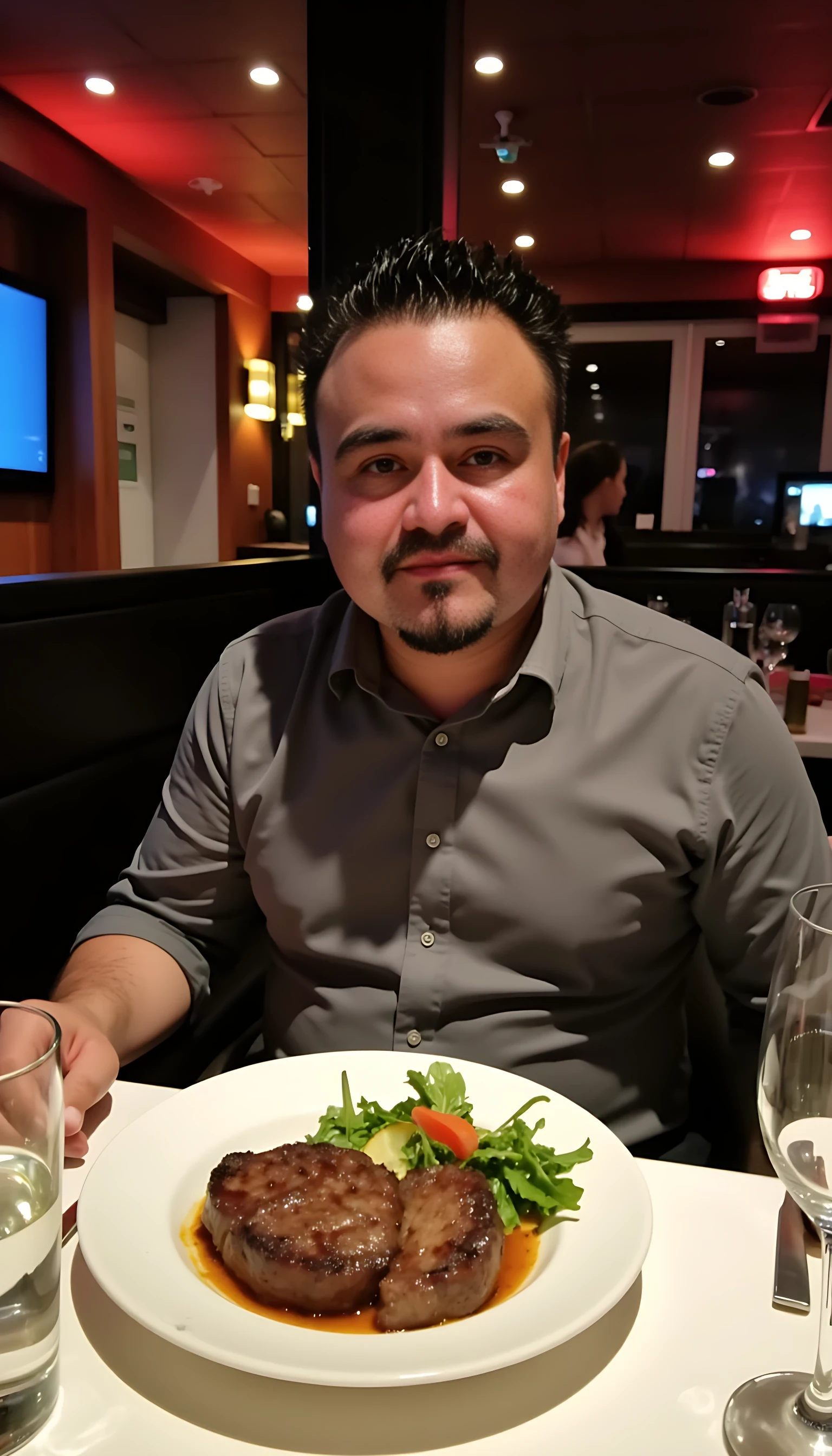 Man average body wearing a  gray dress shirt seating on a table of fancy restaurants with low lights  with a plate of steak and vegetables  and a glass of wine 