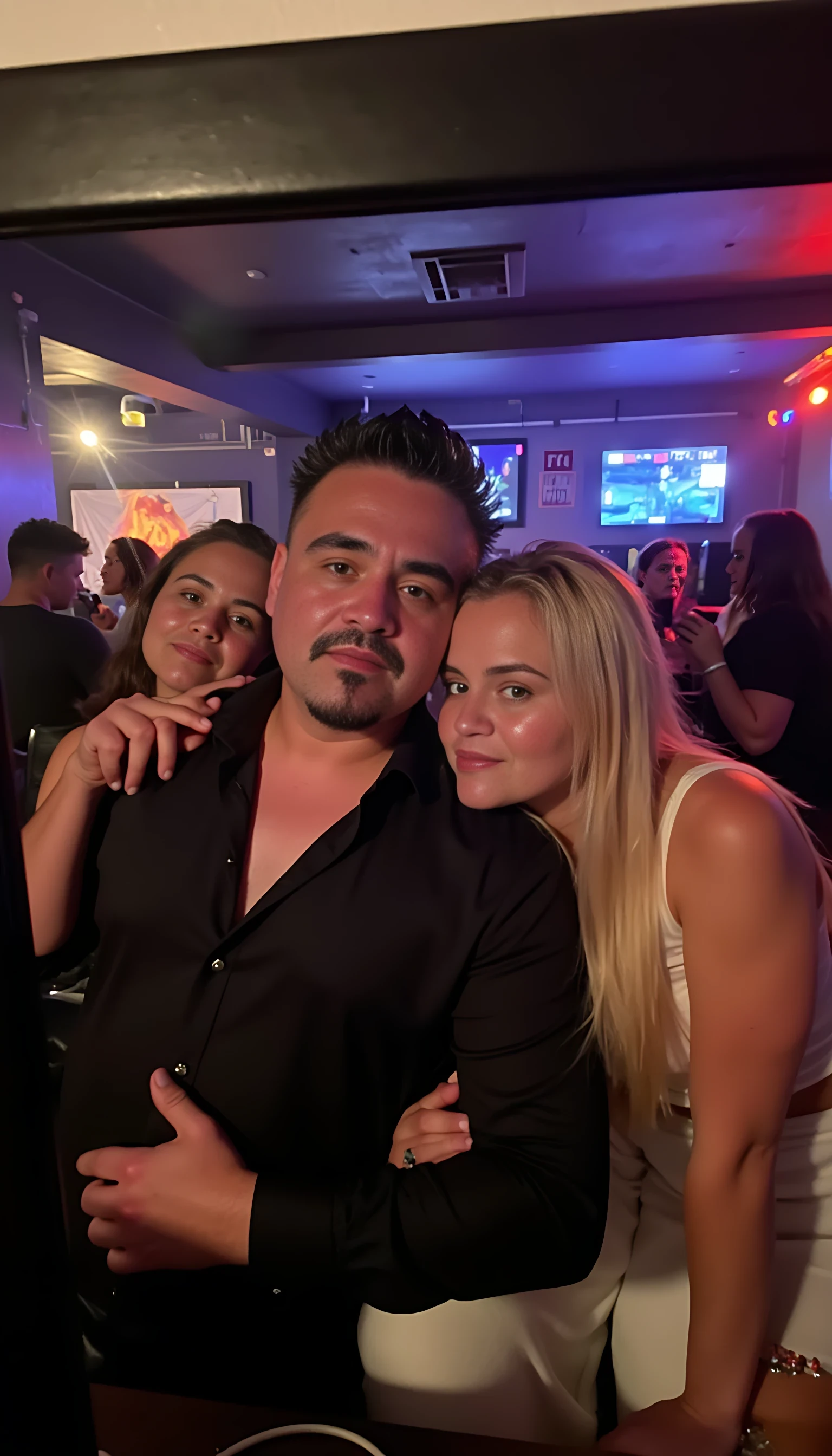 Selfie in a  mirror full man body wearing a  nice black dress shirt   Hugging with 5 blonde girls in a nightclub background 
