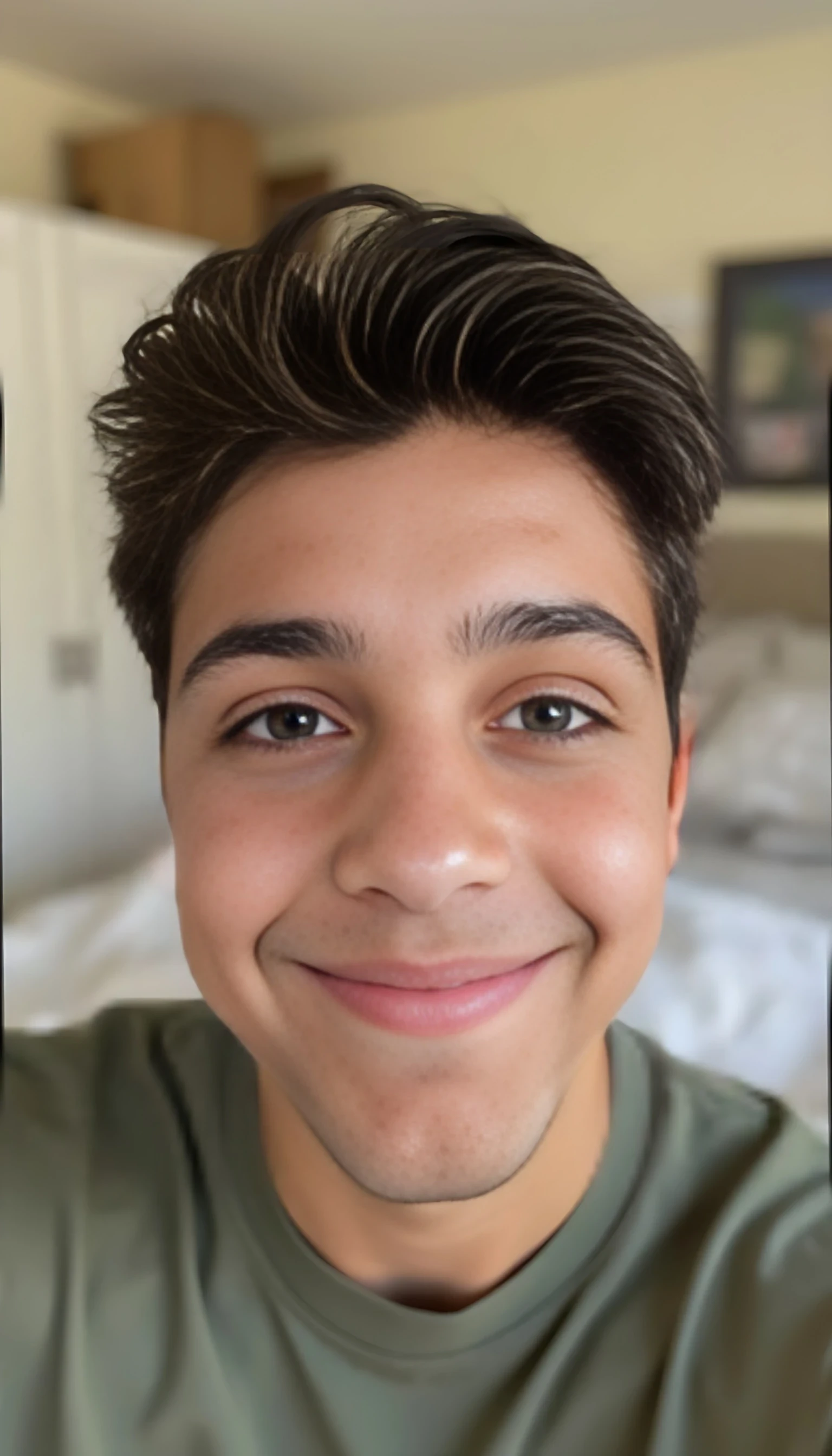 a close up phone selfie of Joey with a blurred background in his home. he's smiling softly at the camera