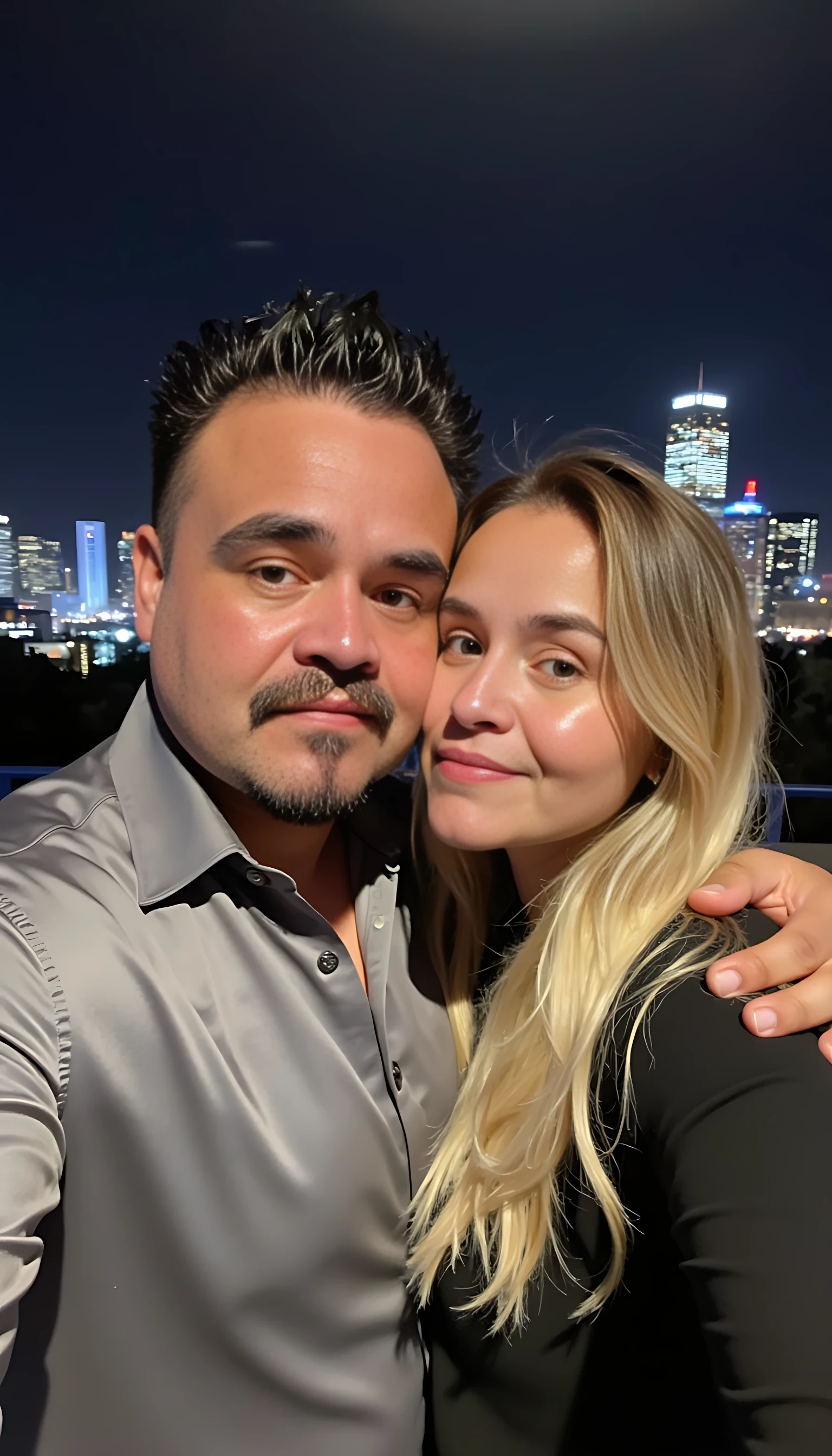 Selfie in a  mirror full man body wearing a  nice gray dress shirt   Hugging a beautiful blonde woman with blue eyes girl in a  big city night lights background 
